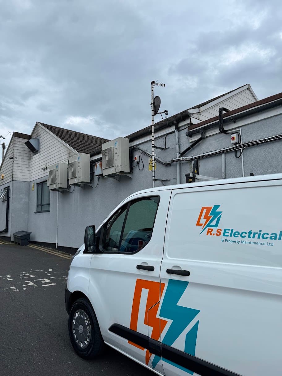 Commercial air conditioning installation at Belt Road Working Men's Club in Cannock, showing external condenser units mounted on the building alongside an RS Electrical vehicle.