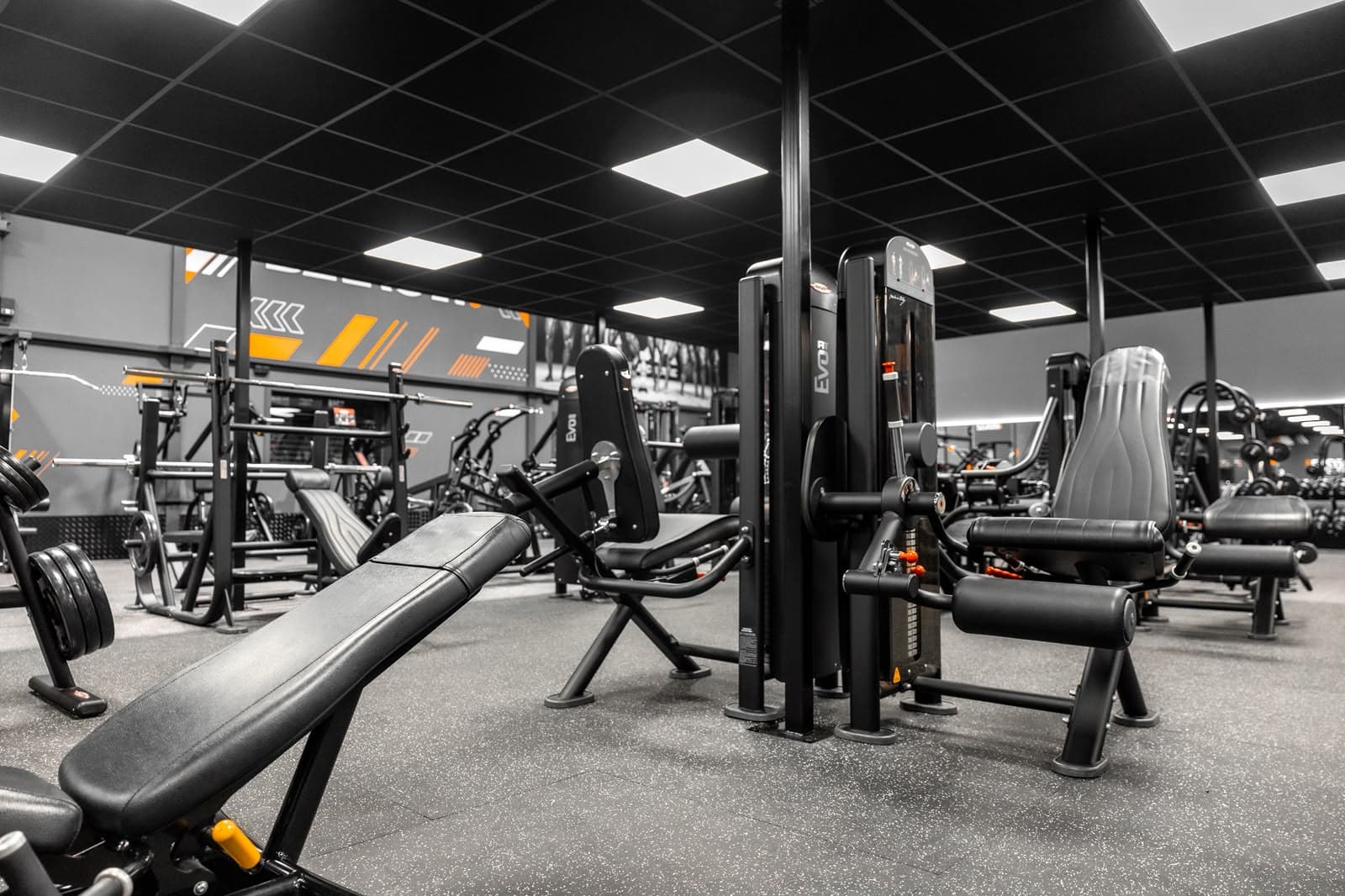 Resistance machine area at Saxon Gym in Cannock, lit by recessed LED panels set into a black suspended ceiling grid.