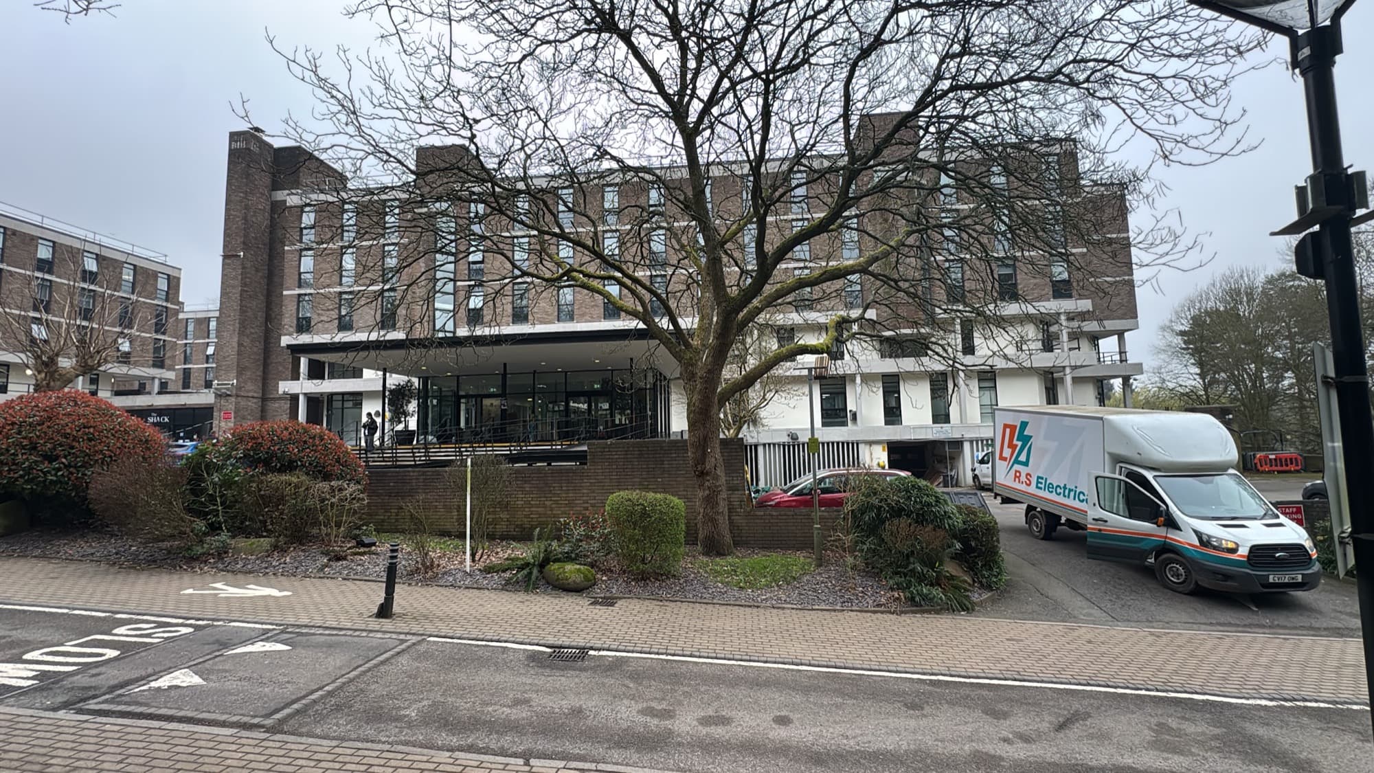 An RS Electrical van parked outside a University of Birmingham residential building, with 'The Shack' signage visible alongside the entrance.